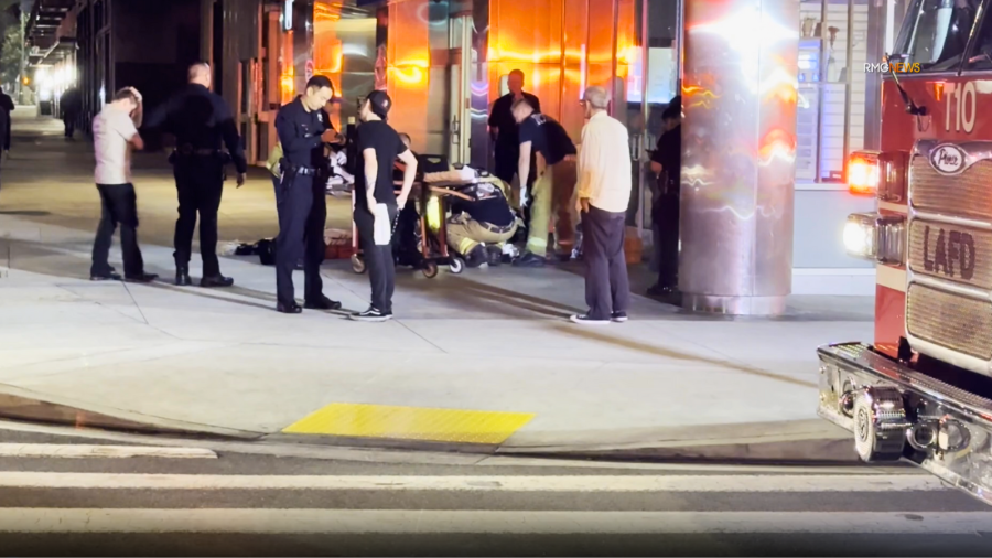 A victim of a fatal double-machete stabbing is seen being transported by paramedics in downtown Los Angeles. June 2025. (RMG News)