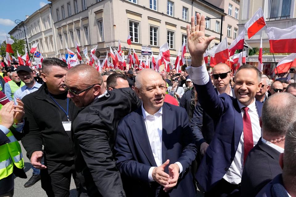Karol Nawrocki, right, waves as he takes part in a march one week ahead of a decisive election in Warsaw Poland on Sunday (AP)