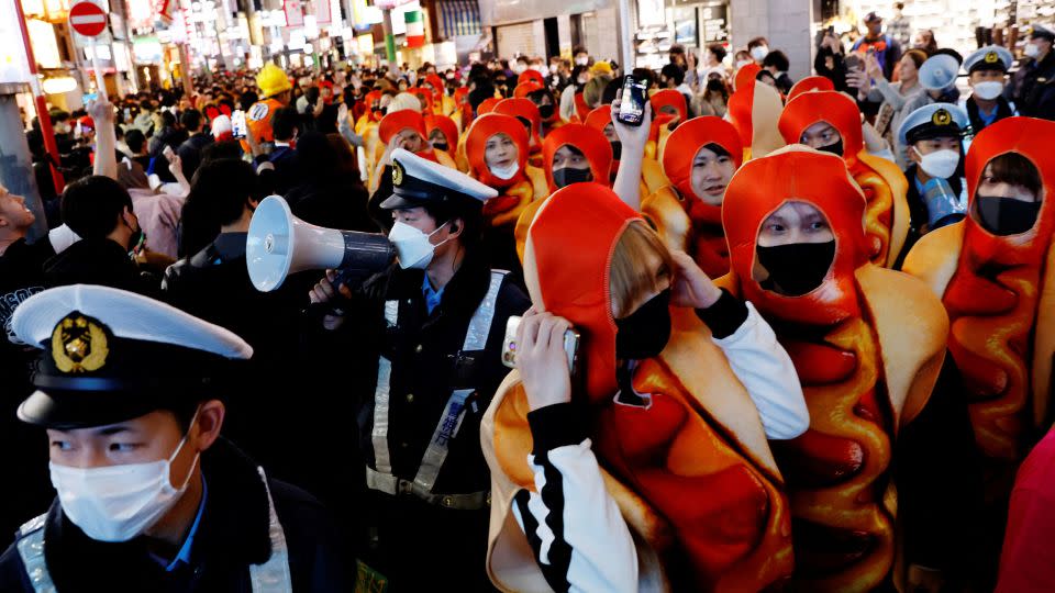 Police officers try to control crowds gathering to celebrate Halloween in Shibuya in 2022. - Kim Kyung-Hoon/Reuters