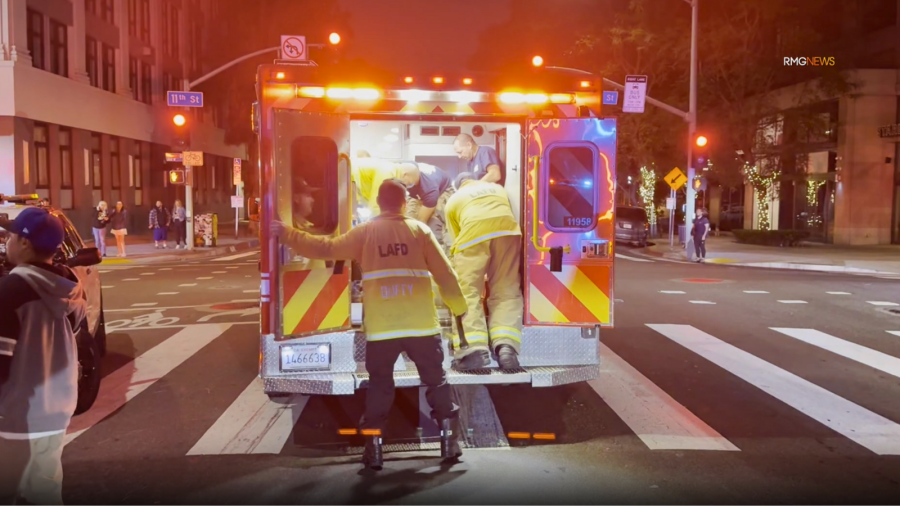A victim of a fatal double-machete stabbing is seen being transported by paramedics in downtown Los Angeles. June 2025. (RMG News)