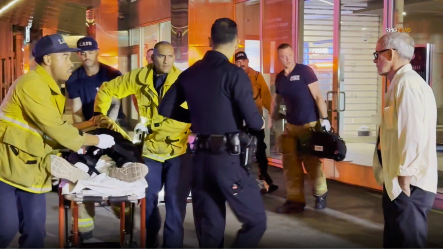 A victim of a fatal double-machete stabbing is seen being transported by paramedics in downtown Los Angeles. June 2025. (RMG News)