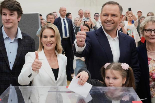 Presidential candidate Karol Nawrocki, second right, poses with his wife Marta Nawrocka, second left, and daughter Katarzyna at a polling station