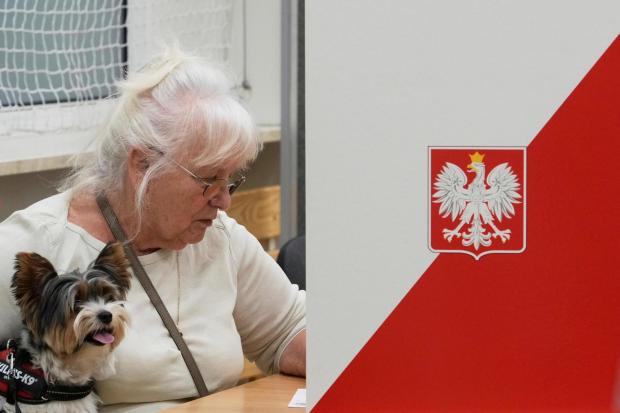 A woman prepares to cast her vote during the presidential election runoff in Warsaw, Poland