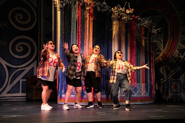 Four actors appear to be singing wholeheartedly.
