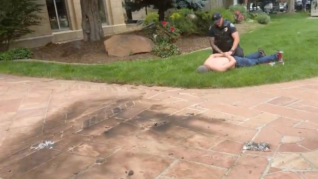 This video still shows a man identified by police as Mohamed Sabry Soliman, right, being handcuffed by an officer in front of the Boulder County Courthouse on the Pearl Street Mall in Boulder on Sunday, June 1, 2025. (Video still via Brian Horwitz)