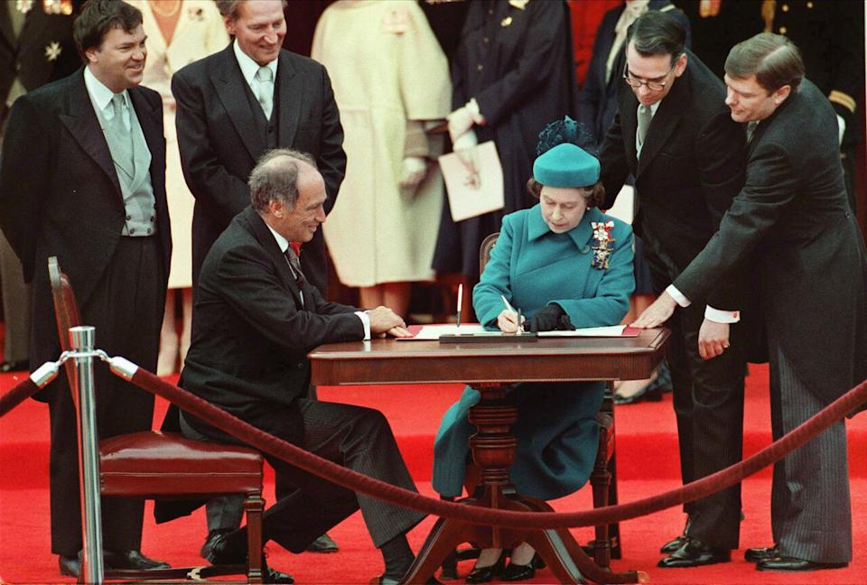 Queen Elizabeth signs Canada's constitutional proclamation as Prime Minister Pierre Trudeau looks on, in Ottawa, April 17, 1982.