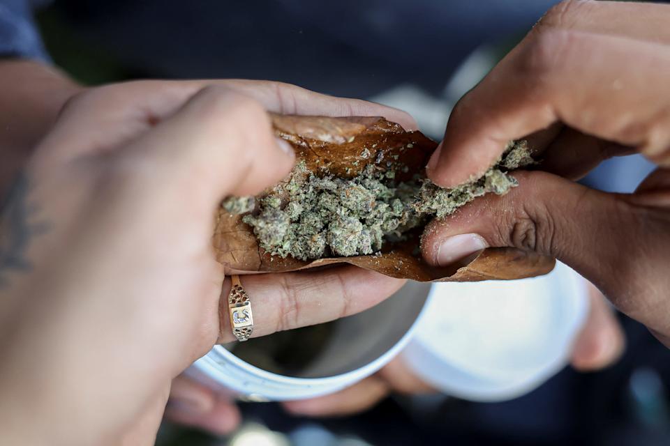 People roll a blunt during the informal annual cannabis holiday, corresponding to the numerical figure widely recognized within the cannabis subculture as a symbol for all things related to marijuana, in Denver, Colorado, U.S., April 20, 2023.