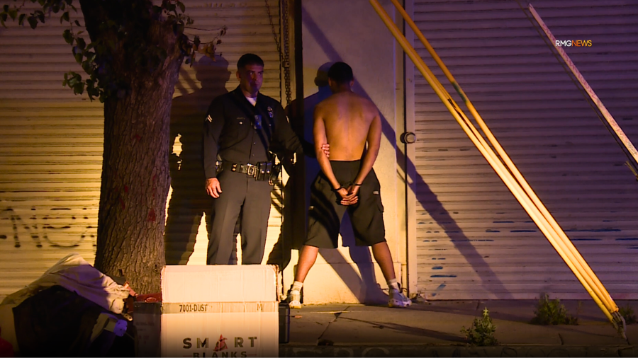 The suspect of a fatal double-machete stabbing is seen under arrest in downtown Los Angeles. June 2025. (RMG News)