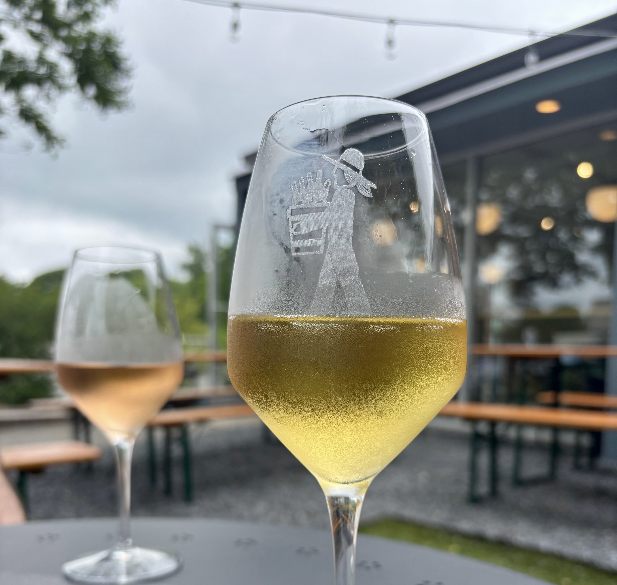 A glass of sparking wine and a glass of rose sitting on a black metal table outside of Sidetracked Wine Co. in Chamblee, GA. 