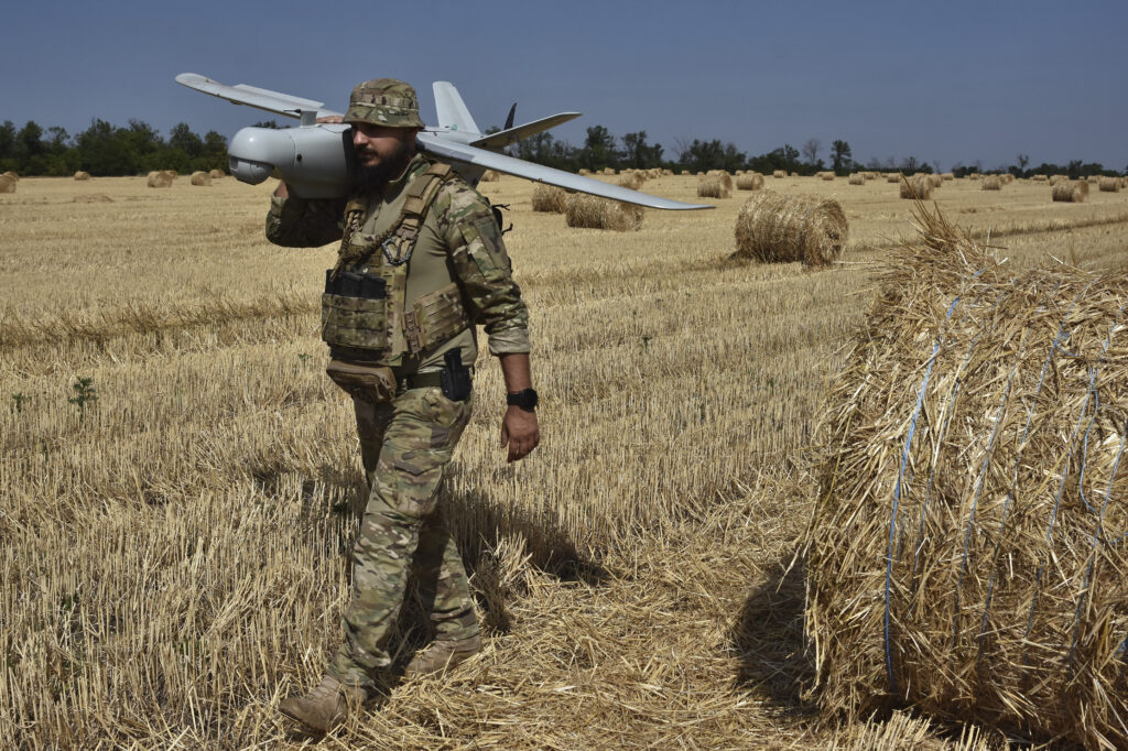 A soldier of Ukraine's National Guard 15th Brigade carries a reconnaissance drone Leleka on a wheat field to determine Russian positions near the front line in Zaporizhzhia region, Ukraine, Monday, July 29, 2024.